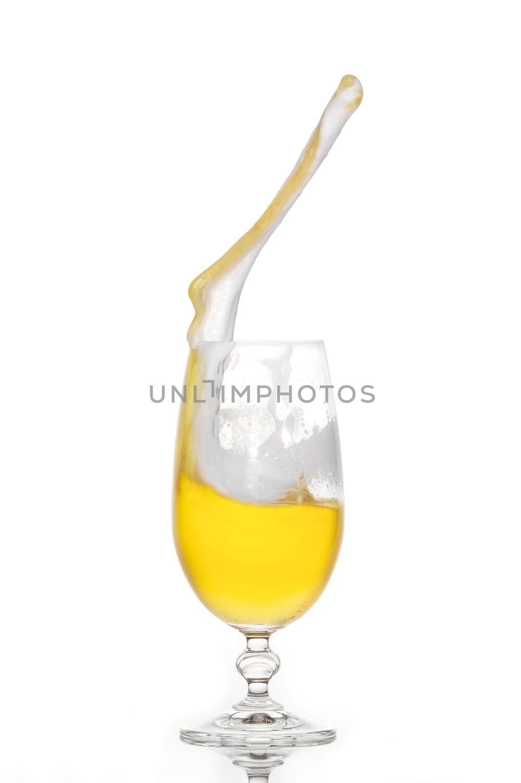 Splashing beer in a glass with little foam