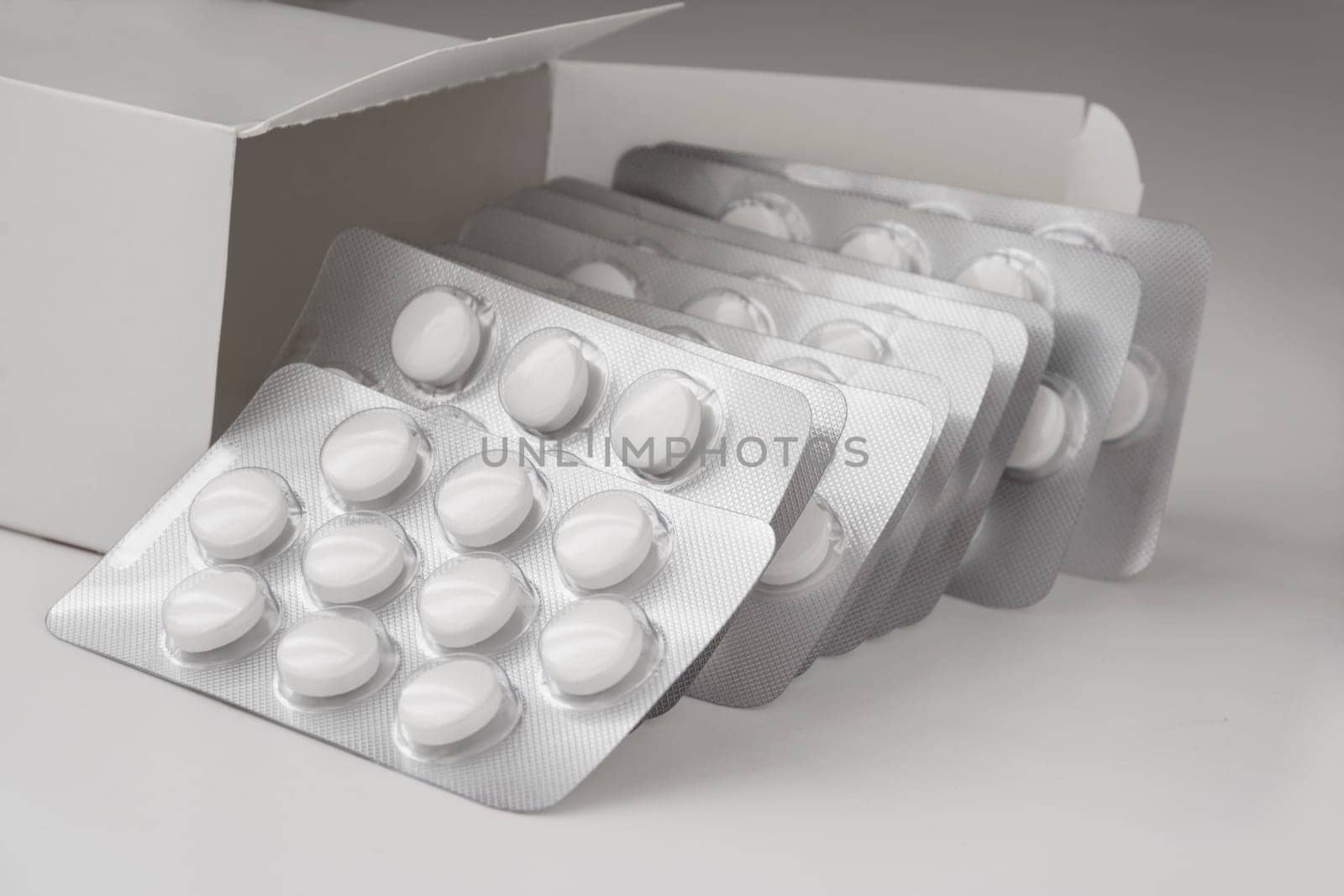 Colse Up View, Multiple Loafs of Tablets Getting Out Form the Box over gray background with shadow.
