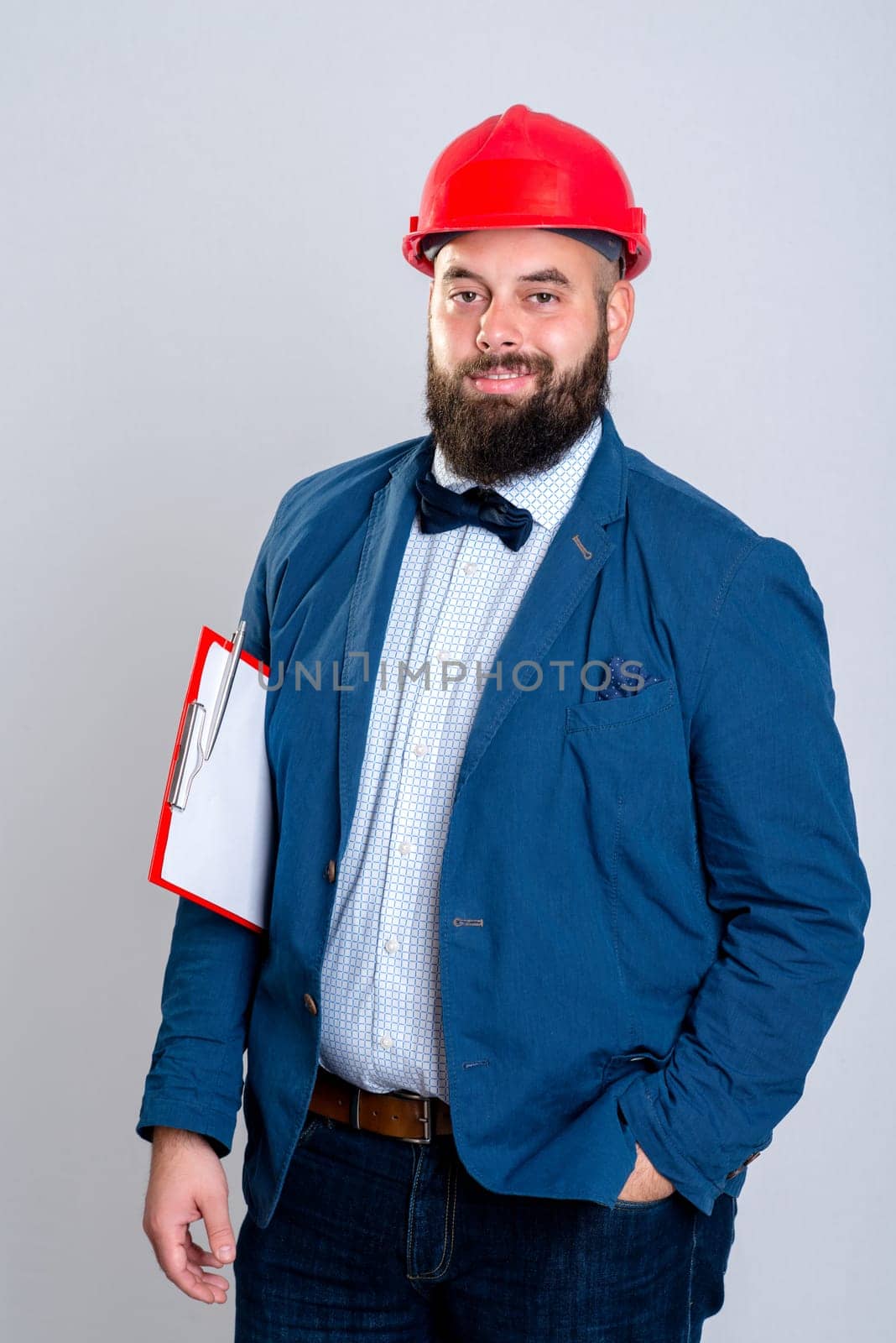 portrait of a young architect with red helmet and clipboard