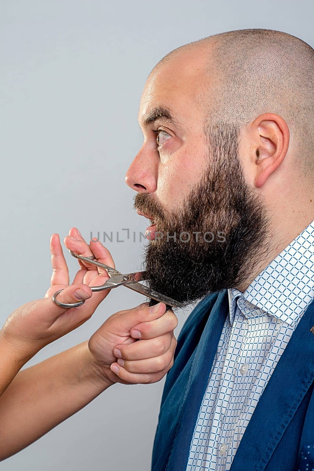 young man is not so happy with beard- cutting