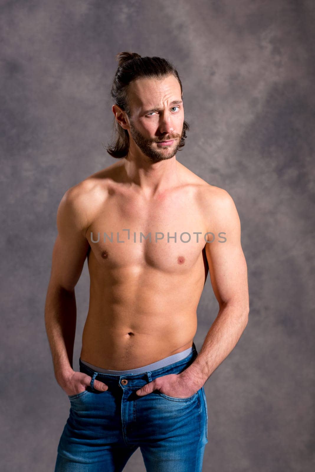 young white man exercised body in front of dark background looking amazed