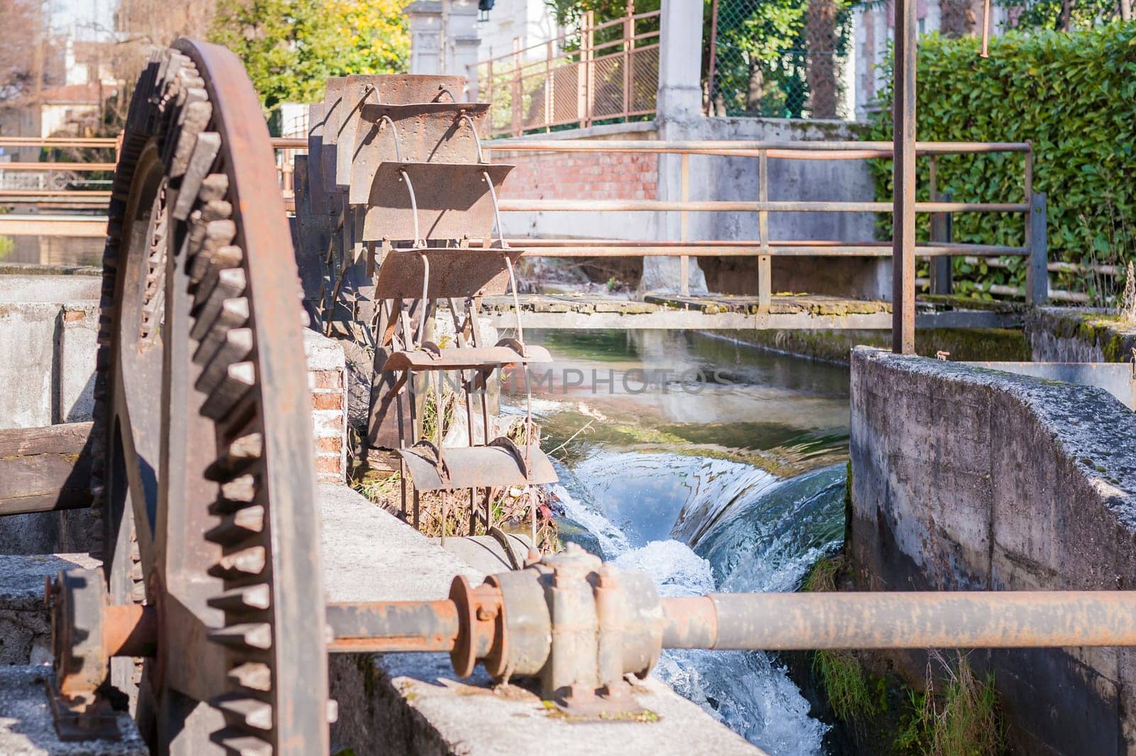 Old iron wheel a watermill. Ruins of a watermill.