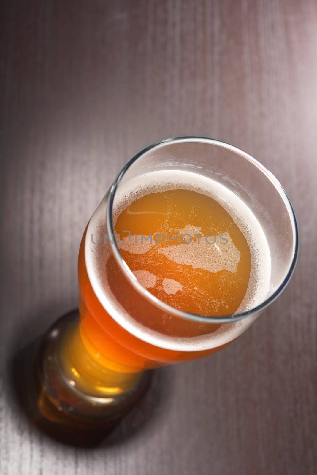 Close-up of a beer glass with foam on the table