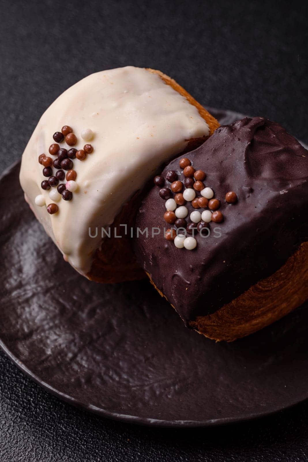 Round sweet New York roll croissant with chocolate cream filling on a dark concrete background
