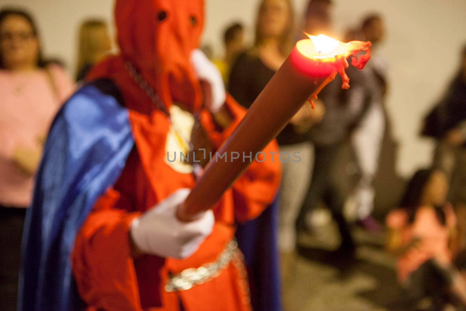 Bearer or nazareno holding large candle at Holy Week Procession, Spain