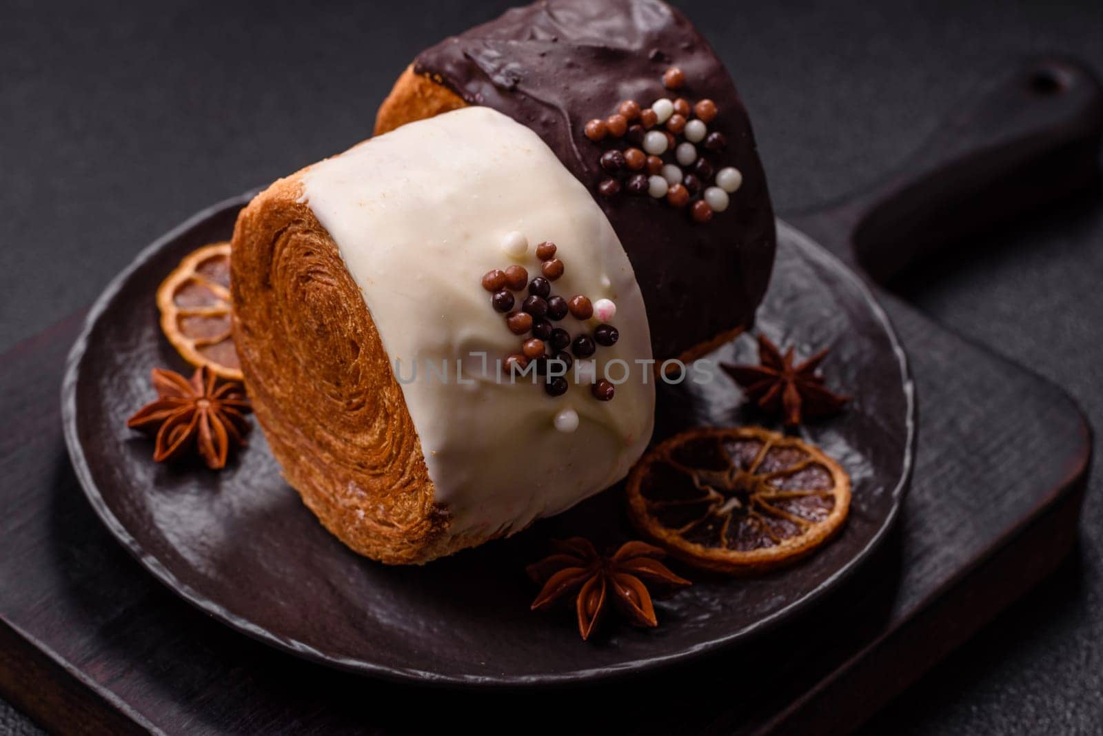 Round sweet New York roll croissant with chocolate cream filling on a dark concrete background