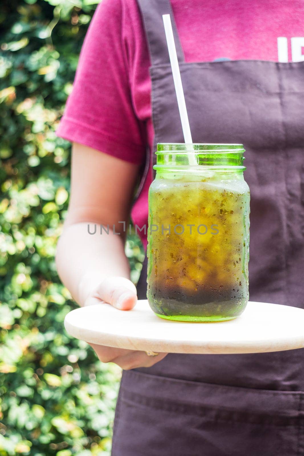 Barista serving iced black coffee, stock photo