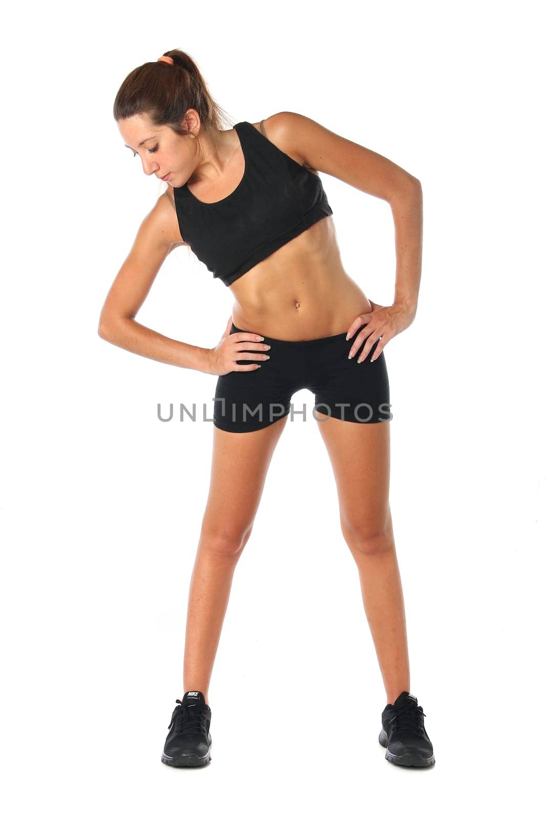 Happy young woman holding doing exercise and stretching over white