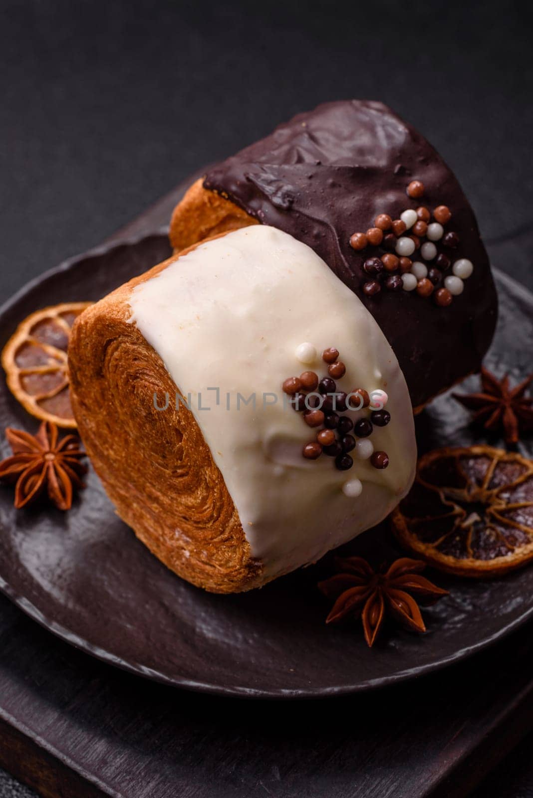 Round sweet New York roll croissant with chocolate cream filling on a dark concrete background