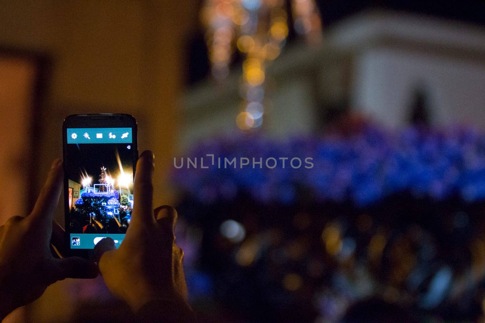 Tourist taking pictures with mobile phone to holy week float, Spain