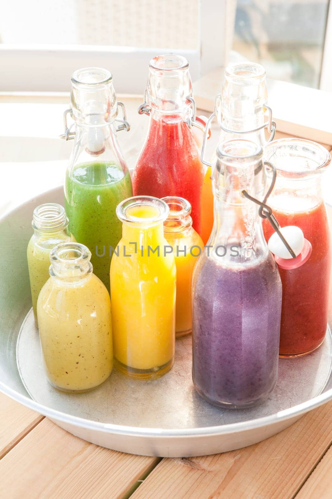 Various colorful smoothies in small bottles