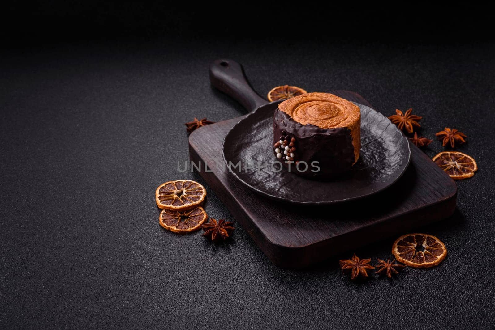 Round sweet New York roll croissant with chocolate cream filling on a dark concrete background