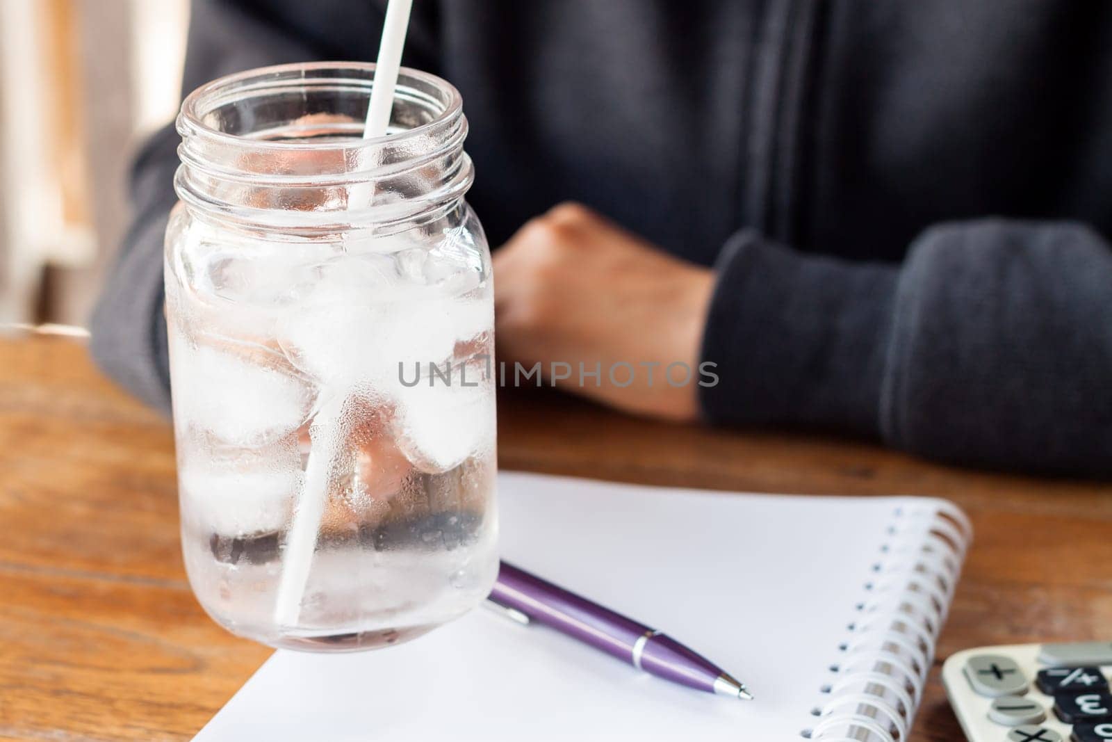 Woman's hand holding a cold glass of water, stock photo