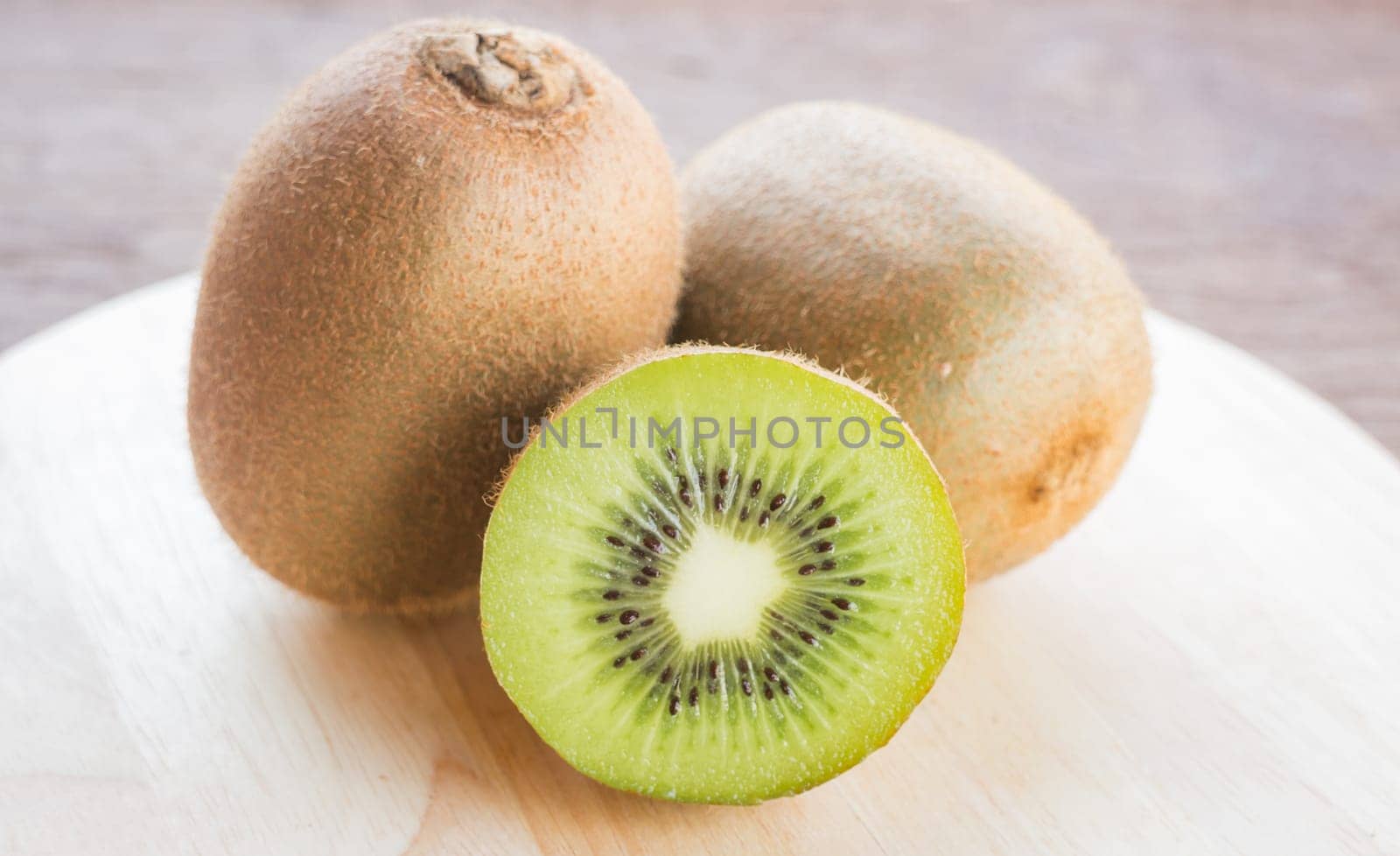 Kiwi fruit on brown wooden background, stock photo