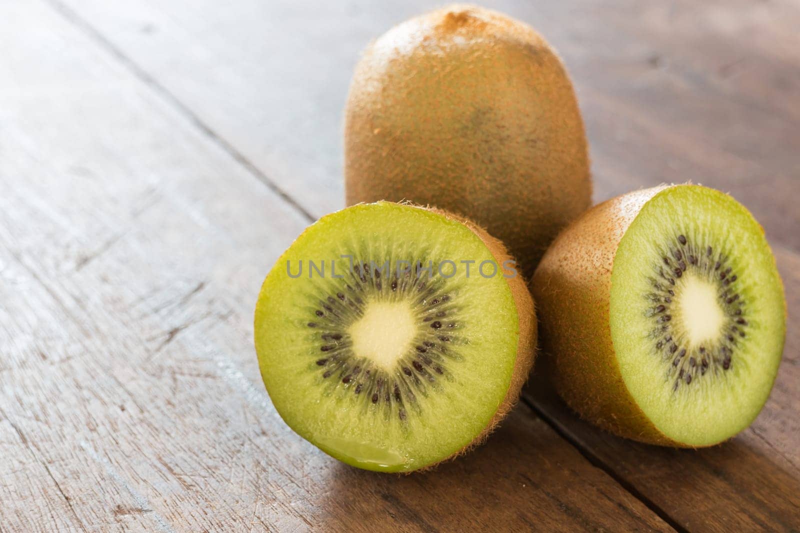 Kiwi fruit on brown wooden background, stock photo