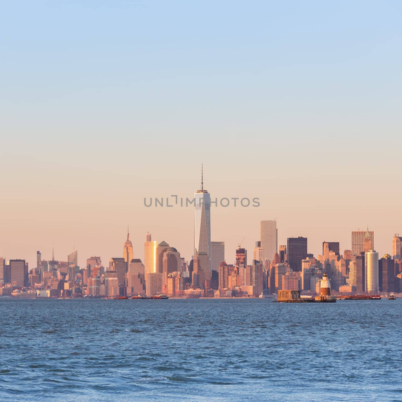 New York City Manhattan downtown skyline at sunset with skyscrapers illuminated over Hudson River panorama. Square composition, copy space.
