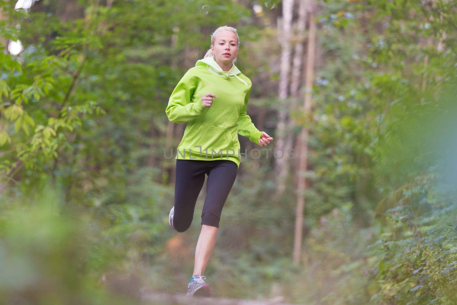 Pretty young girl runner in the forest.  Running woman. Female Runner Jogging during Outdoor Workout in a Nature. Beautiful fit Girl. Fitness model outdoors. Weight Loss. Healthy lifestyle.
