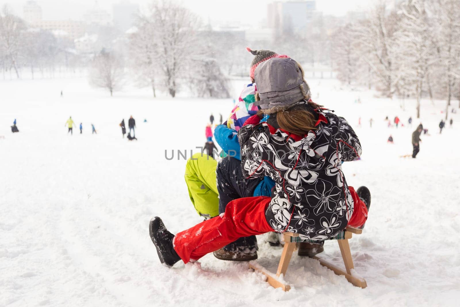 Children sledding and having fun on first winter snow.