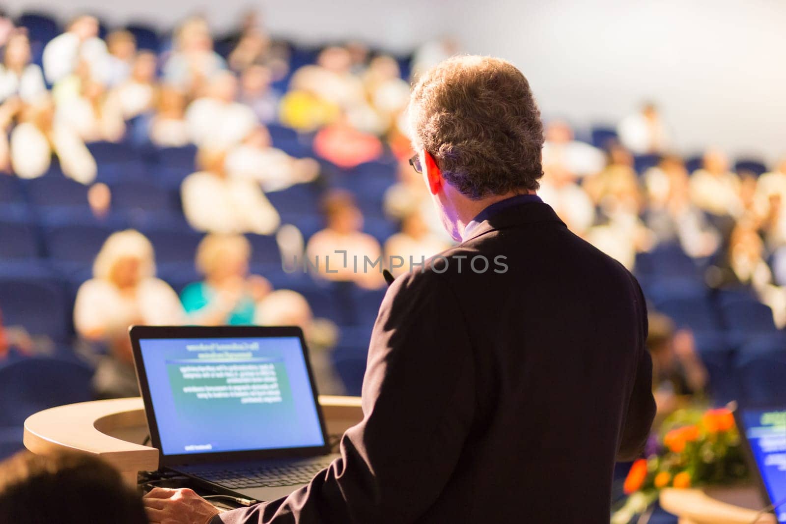 Speaker at Business Conference with Public Presentations. Audience at the conference hall. Entrepreneurship club. Rear view. Horisontal composition. Background blur.