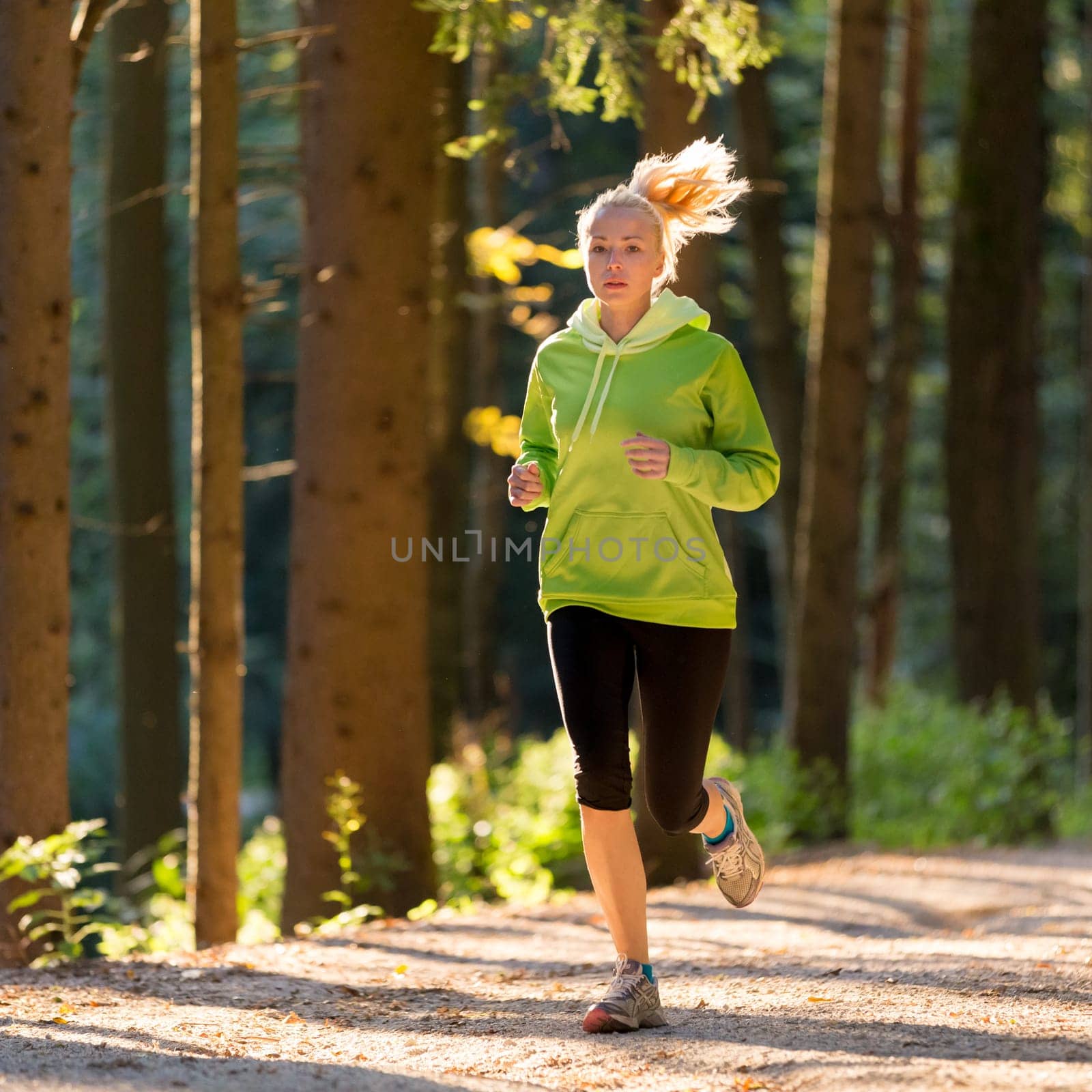 Pretty young girl runner in the forest.  Running woman. Female Runner Jogging during Outdoor Workout in a Nature. Beautiful fit Girl. Fitness model outdoors. Weight Loss. Healthy lifestyle.