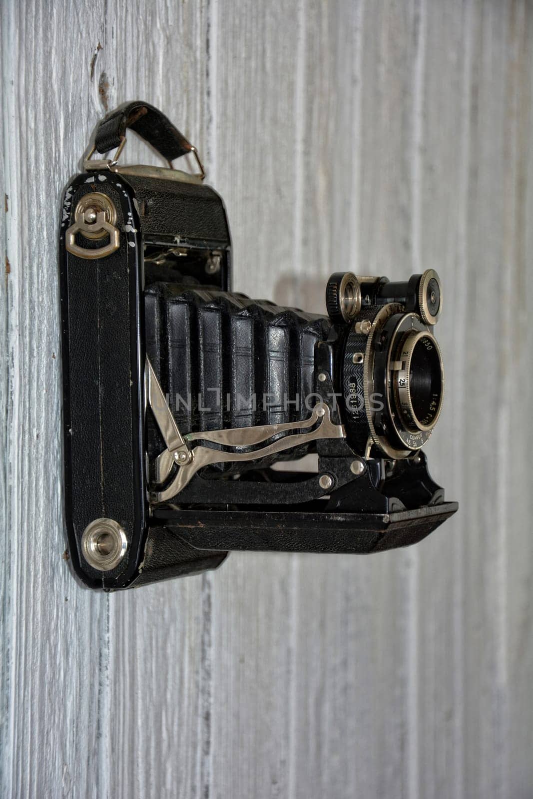 old camera hangs on old white wooden wall