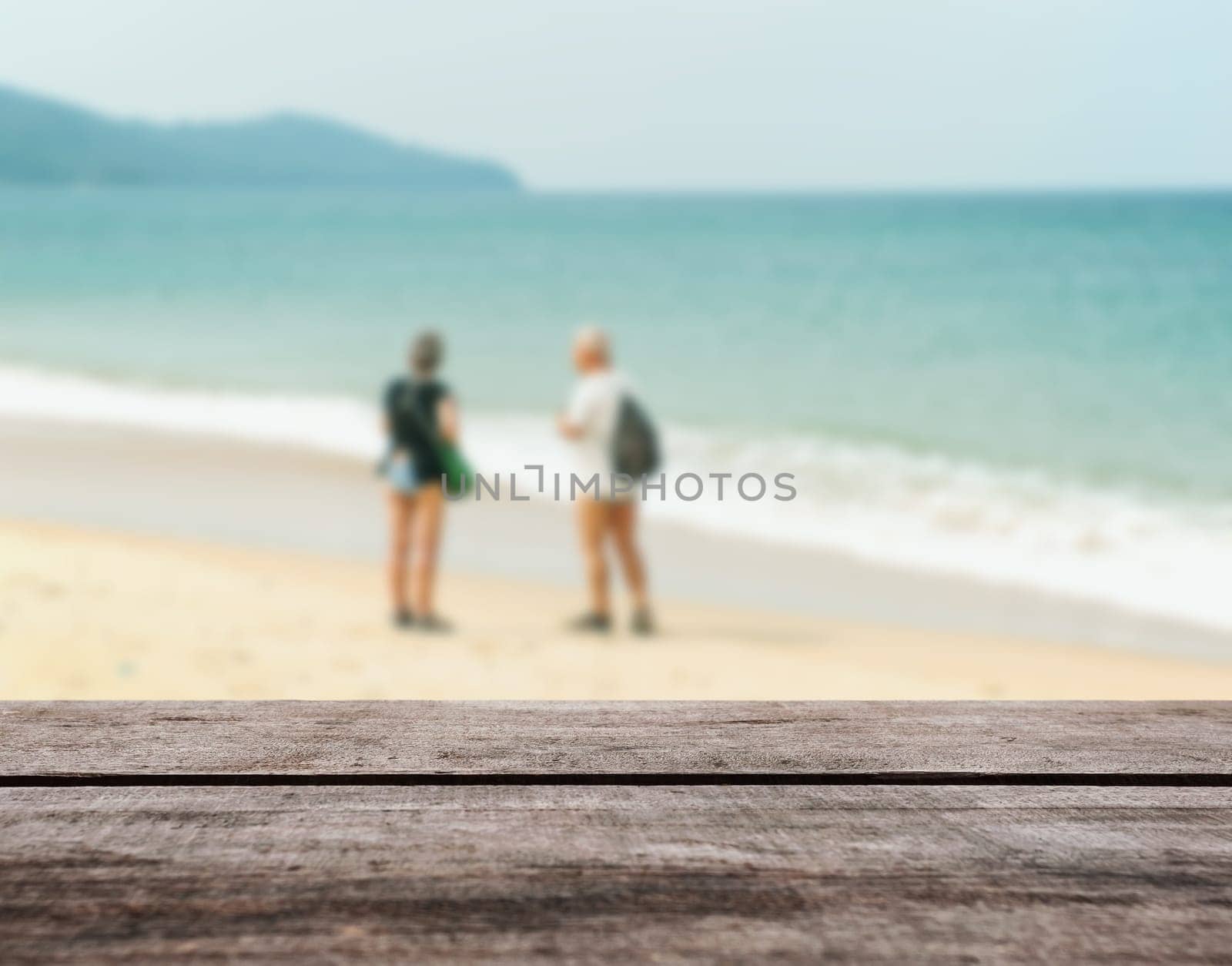 Wood table top on blurred blue sea and white sand beach with some people - Can be used for display or montage your products