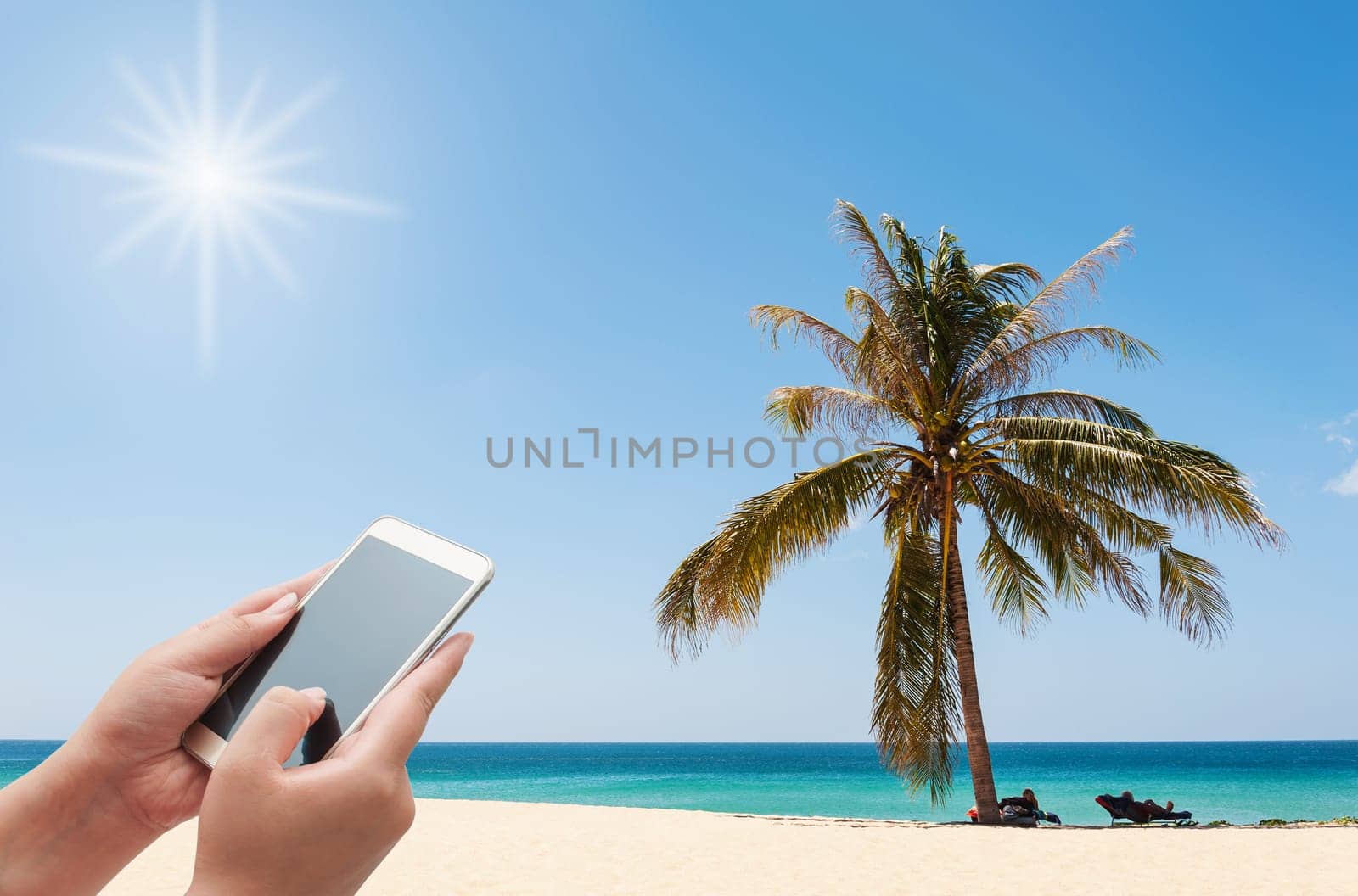 Women using smartphone on the beach with sunlight