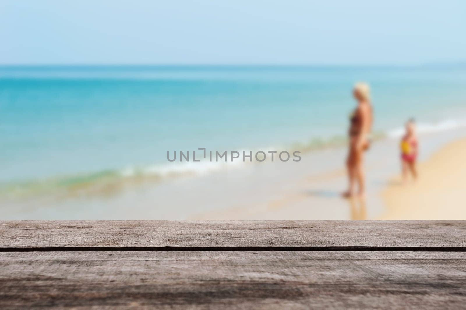 Wood table top on blurred blue sea and white sand beach with some people - Can be used for display or montage your products