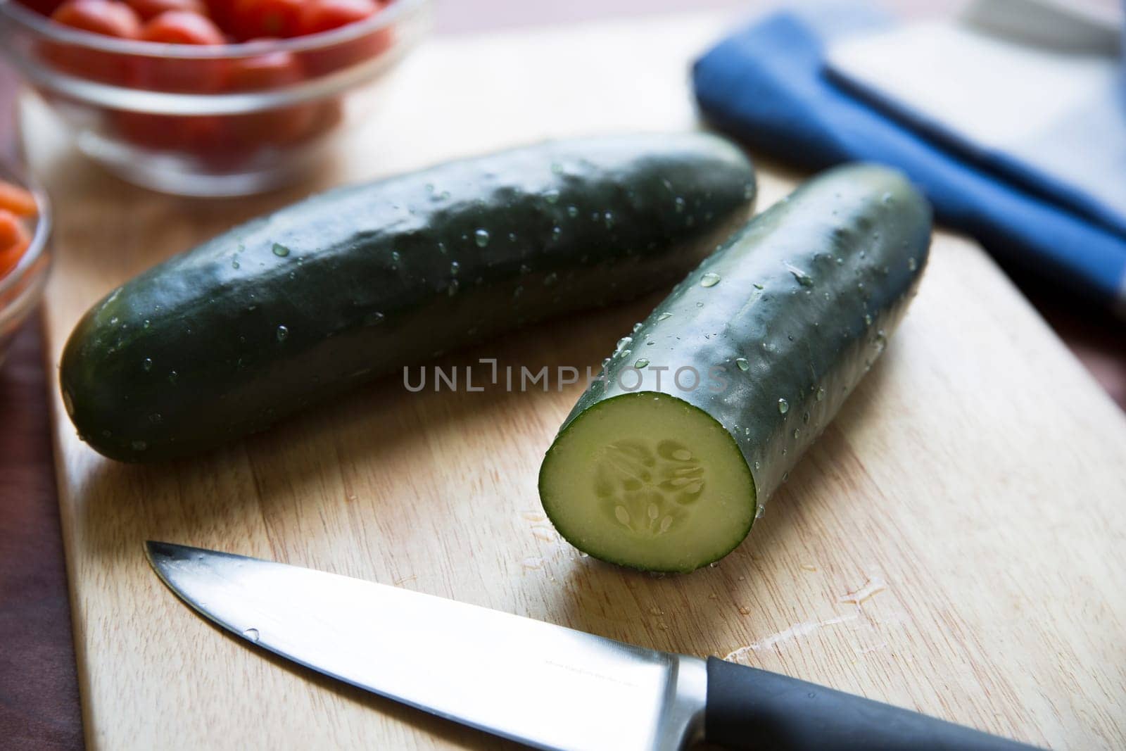 Cucumbers and knife on cutting board.