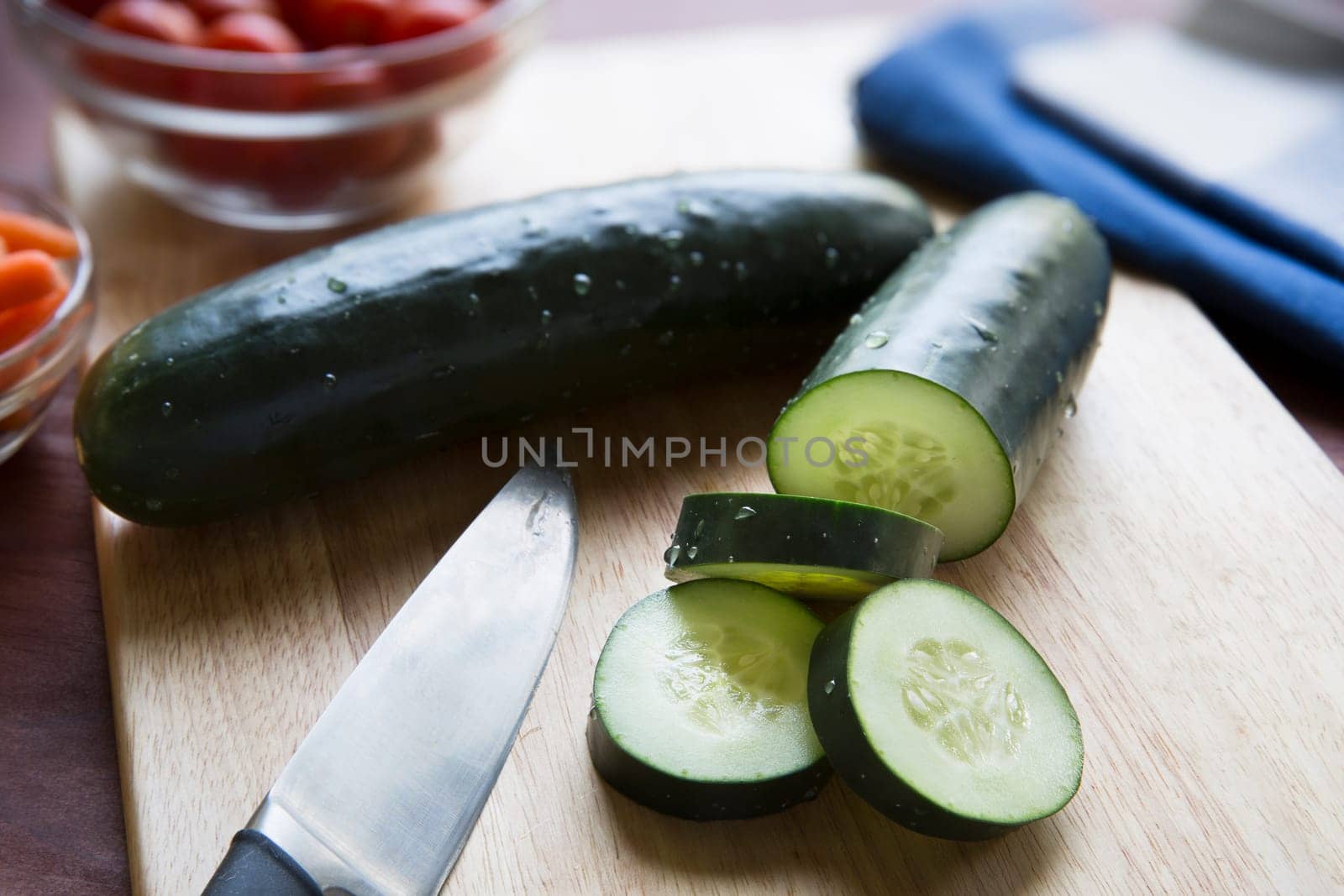 Cucumbers and knife on cutting board.