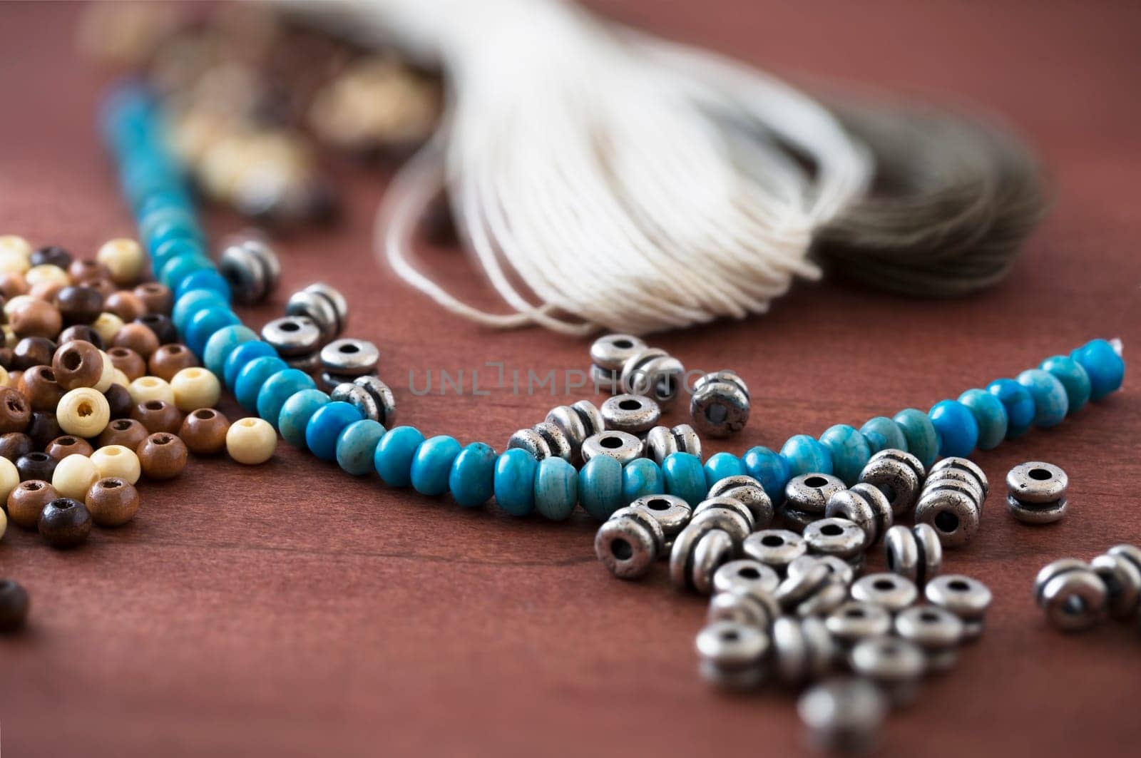 Collection of metal, wooden and turquoise beads with cord for jewelry making.