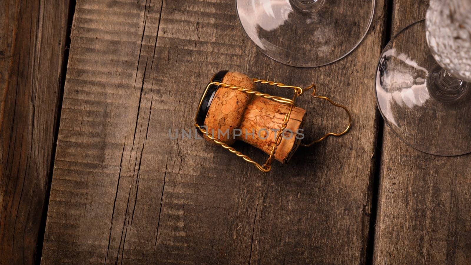 Cork of a champagne bottle against two champagne flutes