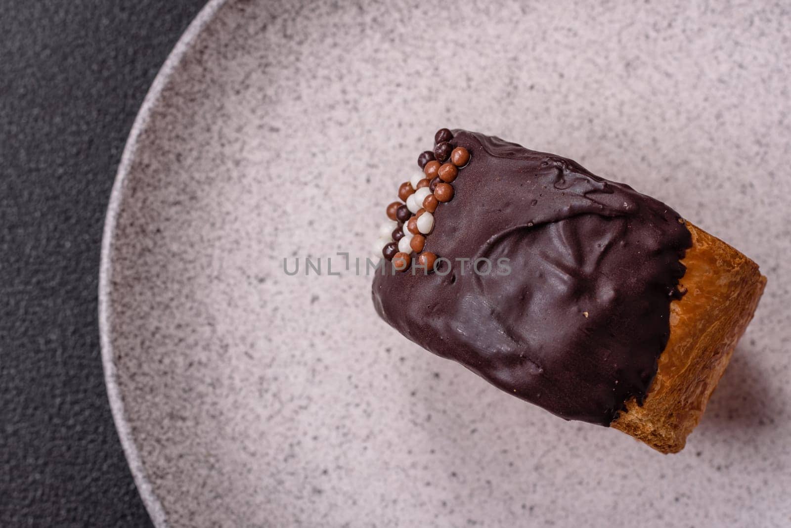 Round sweet New York roll croissant with chocolate cream filling on a dark concrete background