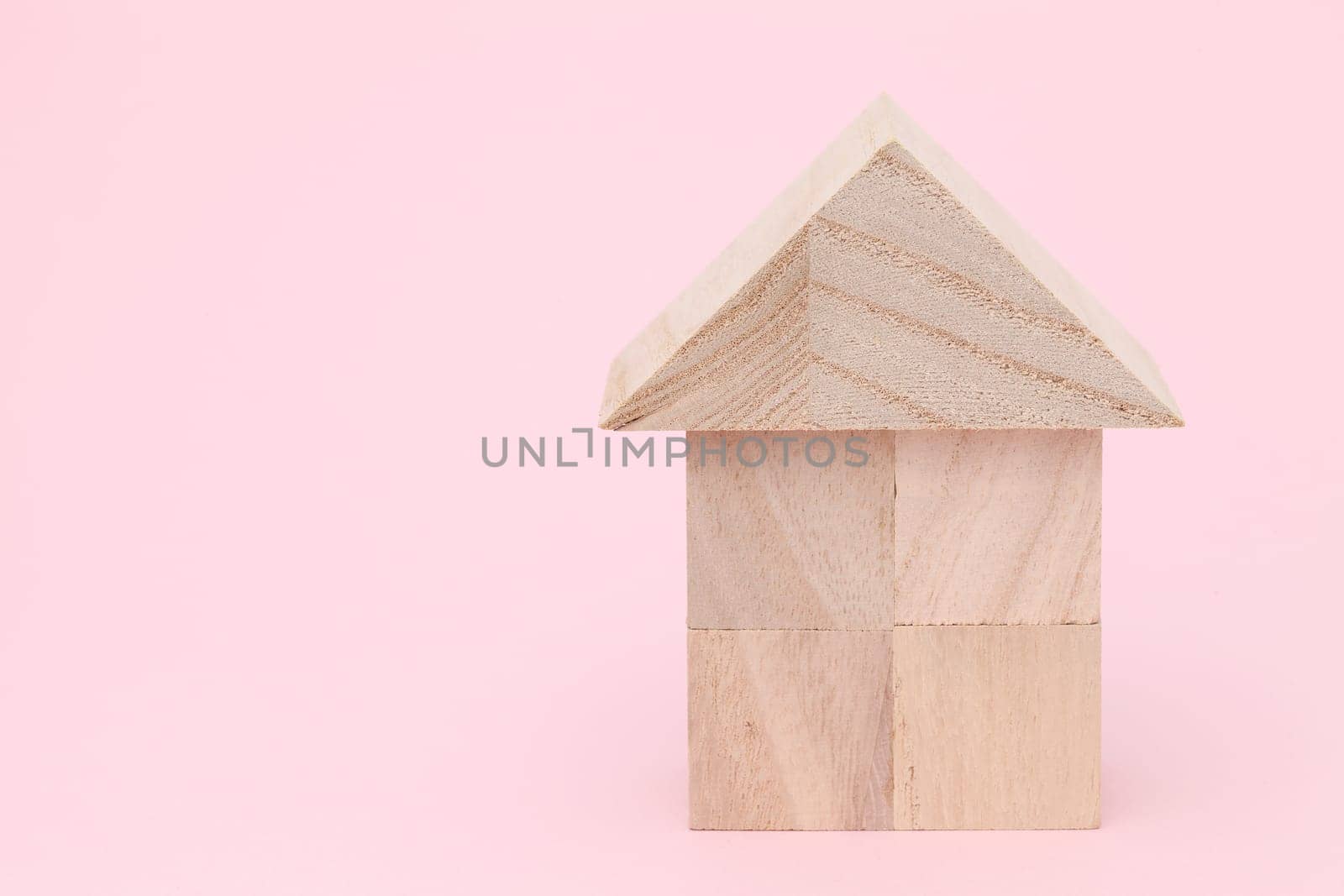 Wooden toy house with natural colored toy blocks