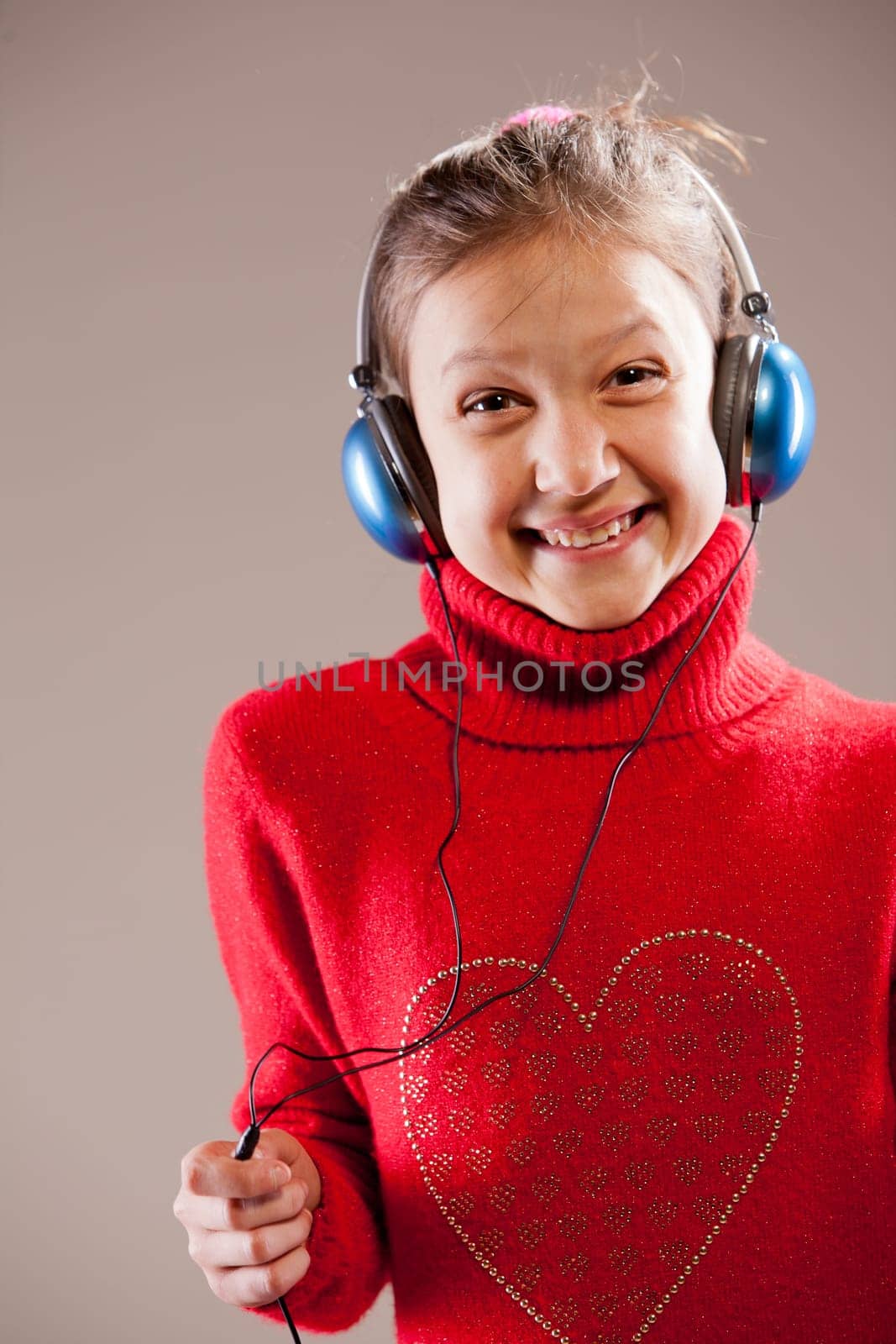 Little girl listening to the music inher blue headphones