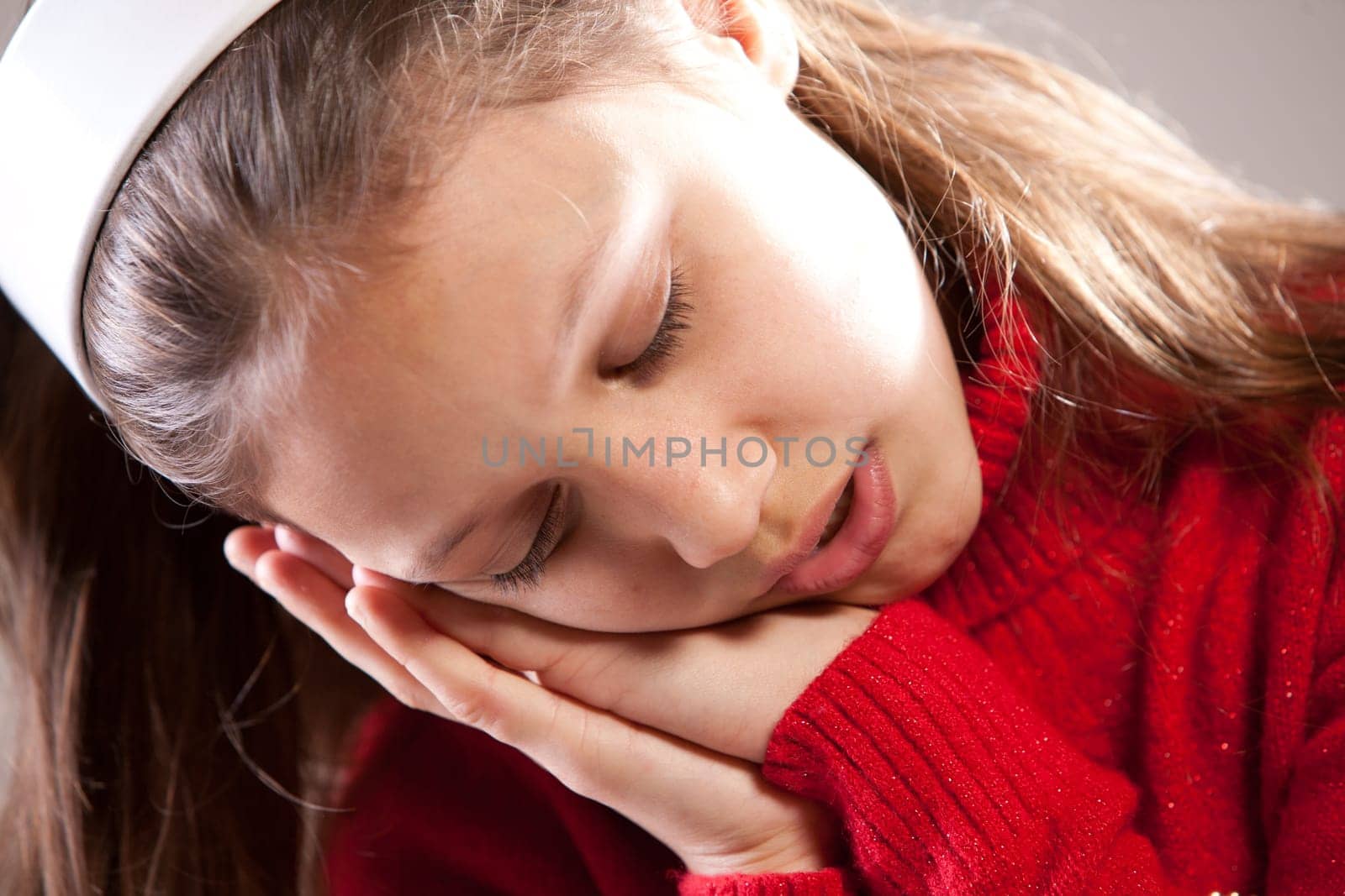 Little girl sleeping with her face on her hands
