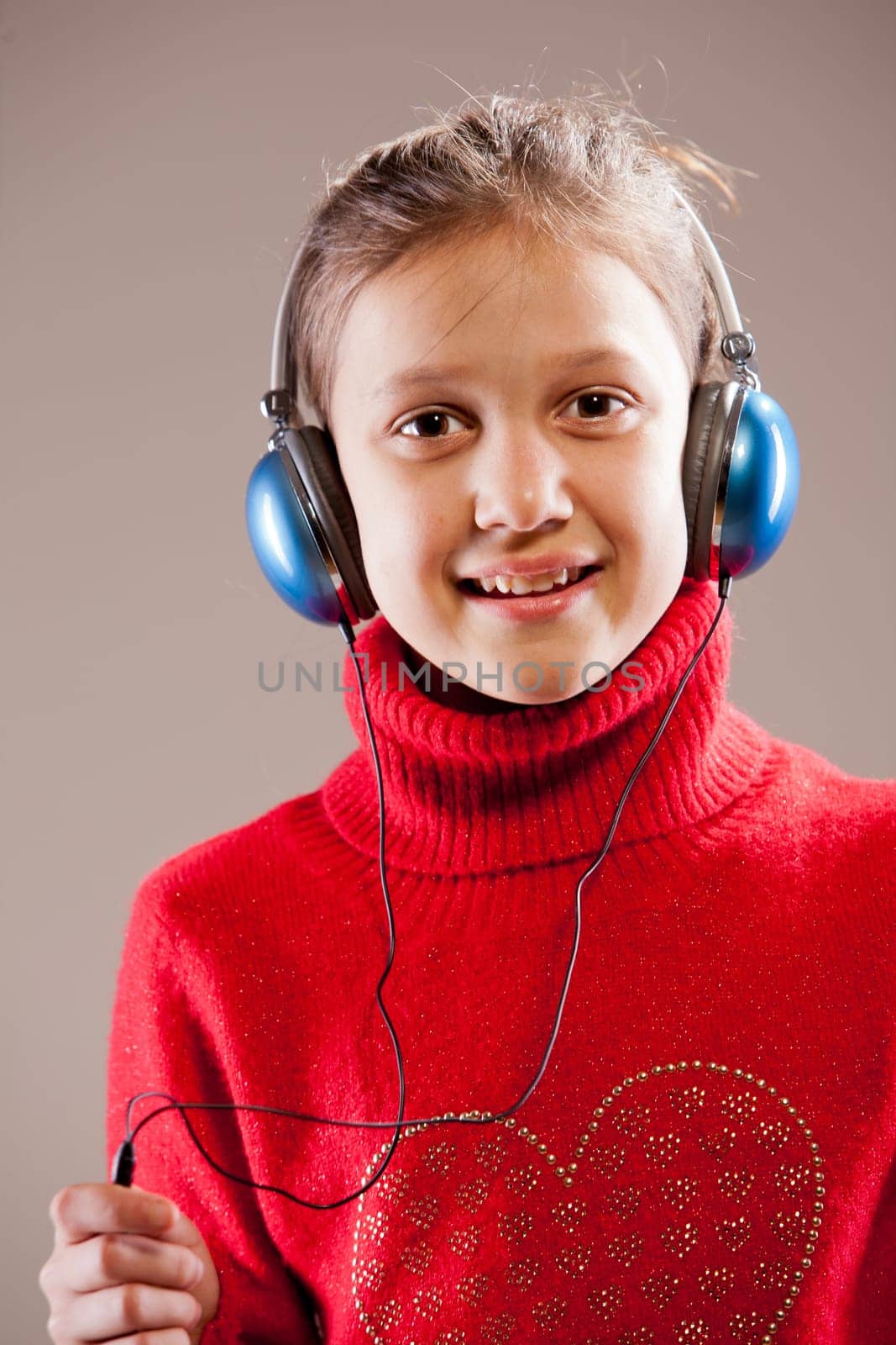 Little girl listening to the music inher blue headphones