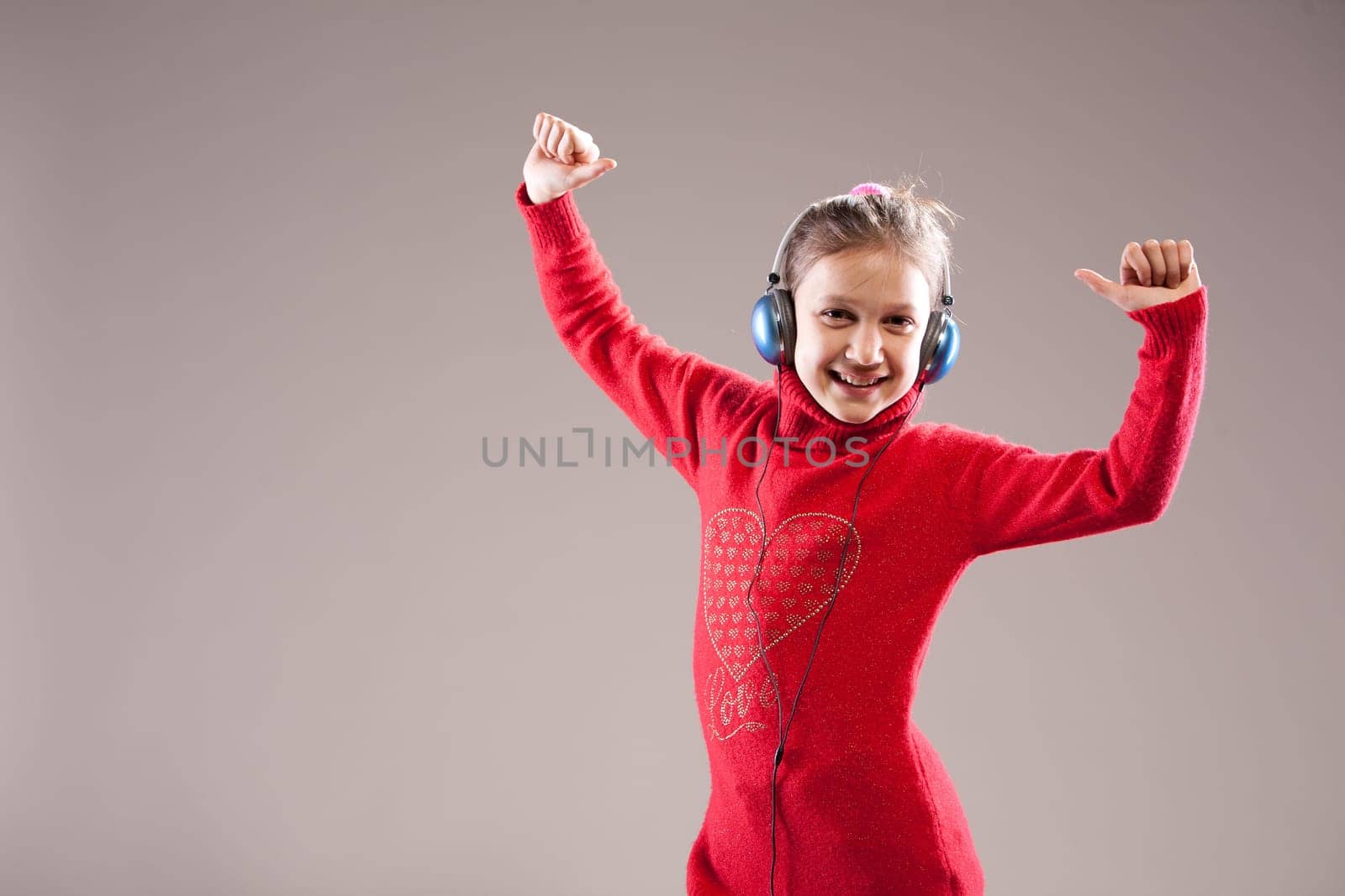 Little girl dancing, listening to her headphones, smiling and exulting