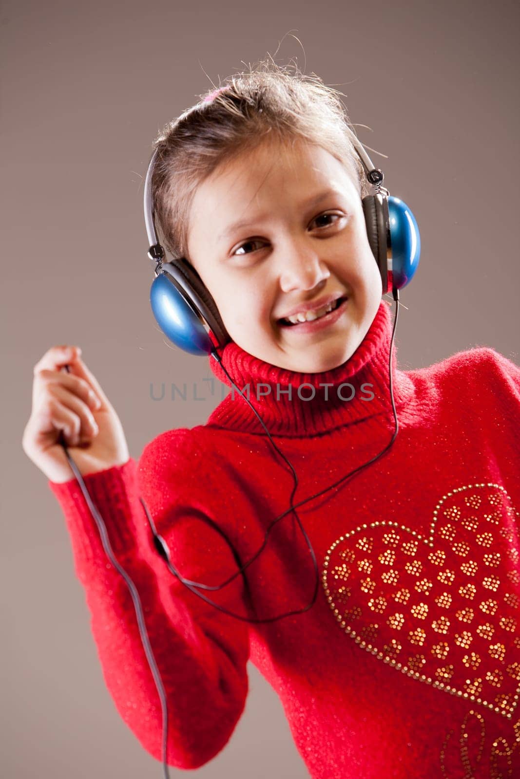 Little girl listening to the music inher blue headphones