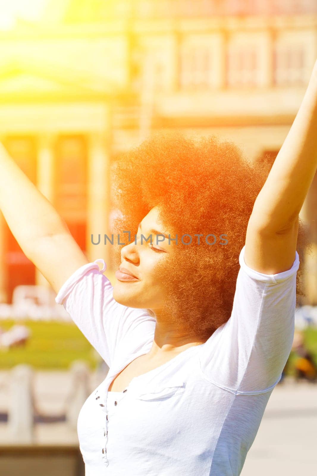 Happy young woman with afro hairstyle in the sun
