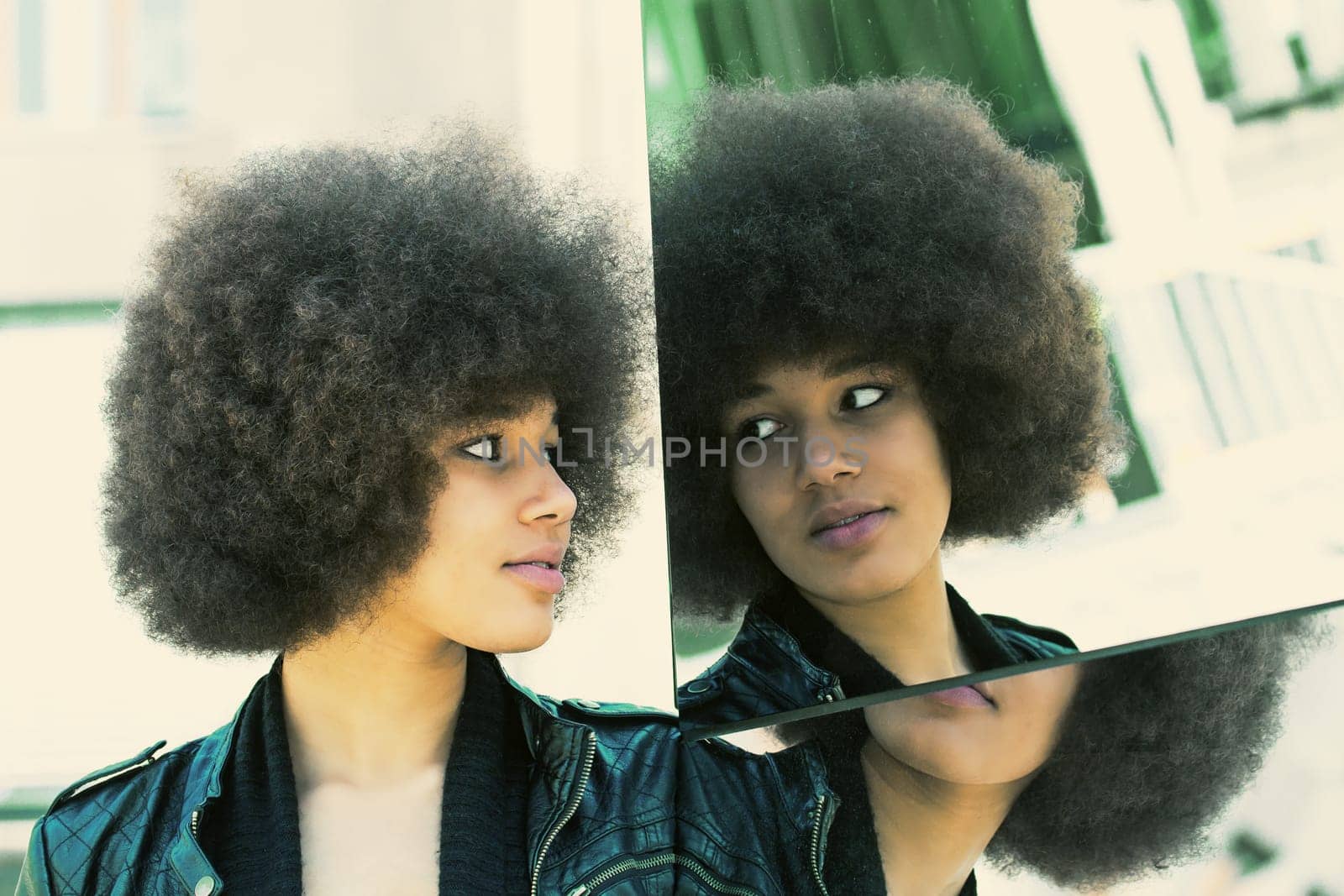 Young dark-skinned woman on a mirror