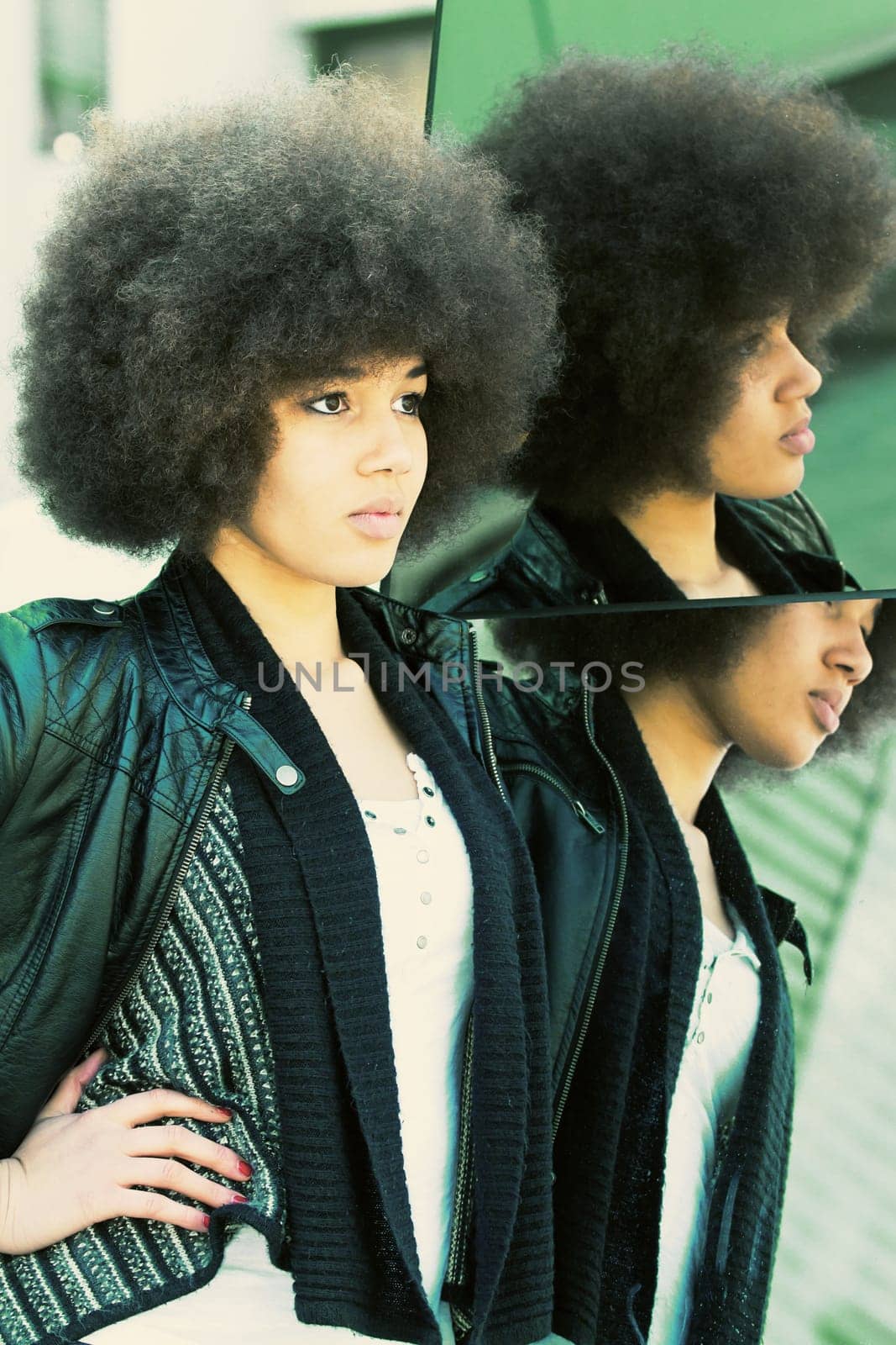 Young dark-skinned woman on a mirror