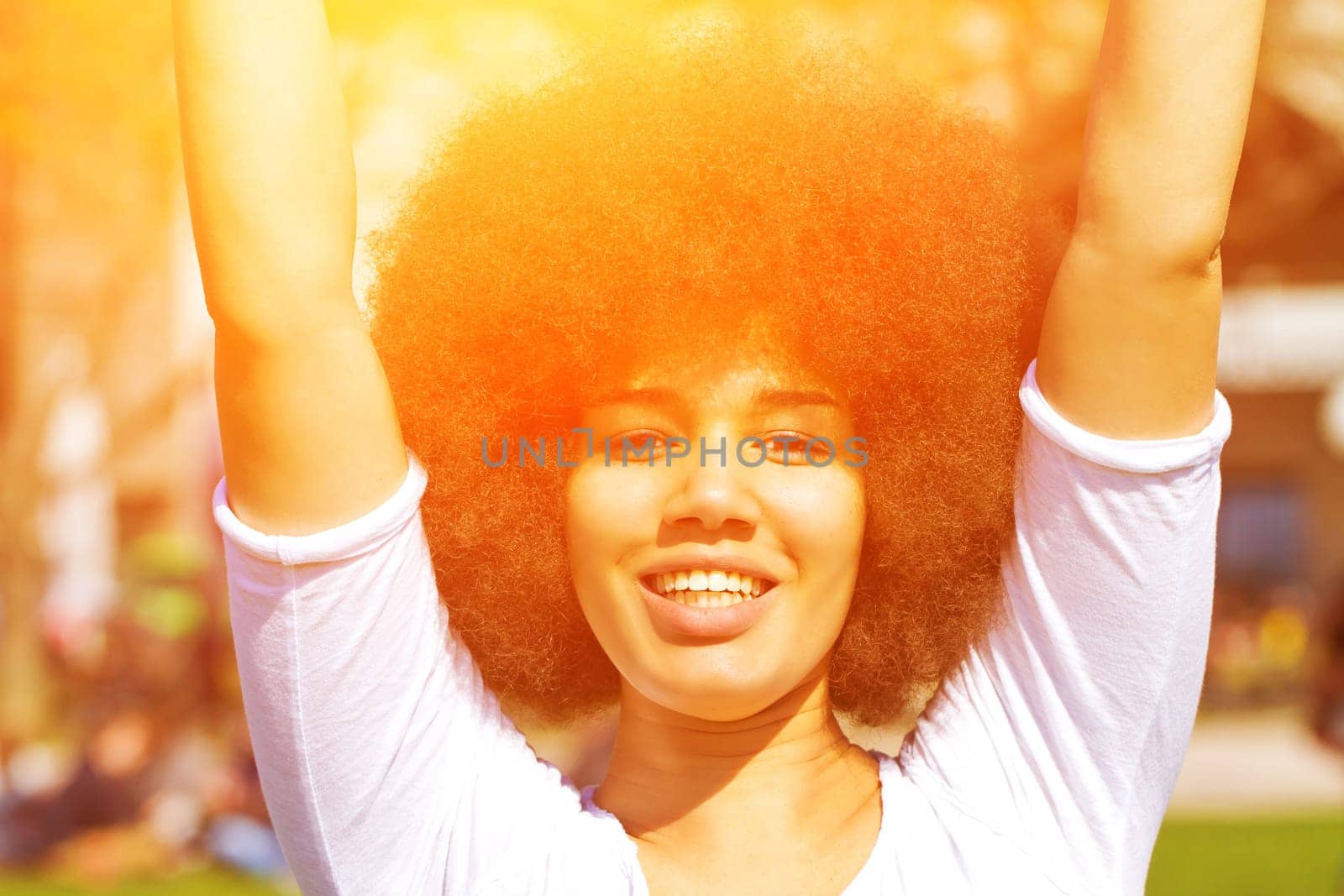 Happy young woman with afro hairstyle in the sun