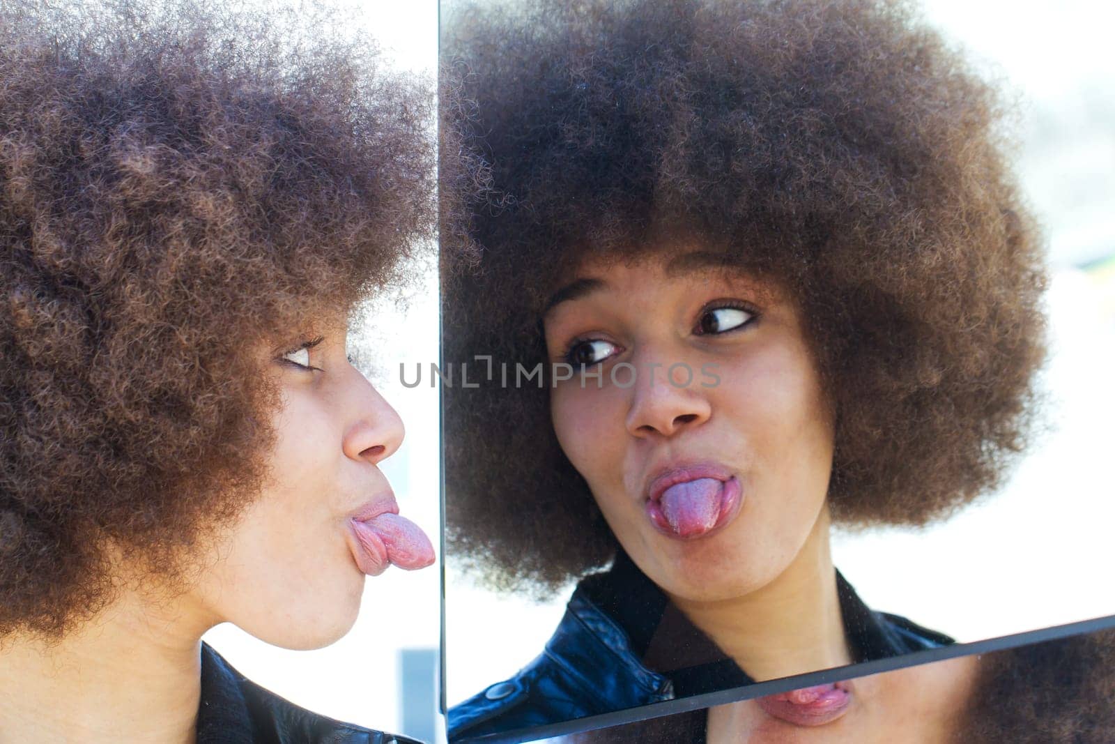 Girl with afro hairstyle sticks out her tongue