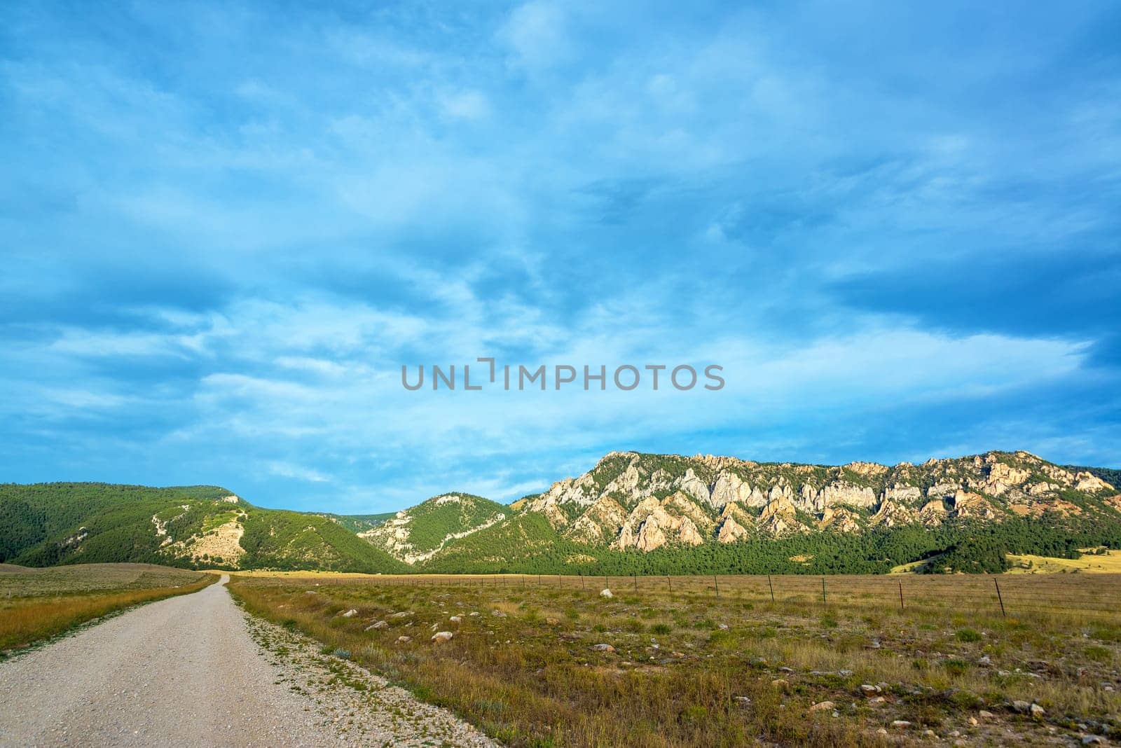 Dirt road leading to Bighorn Mountains with a dramatic sky near Buffalo, Wyoming