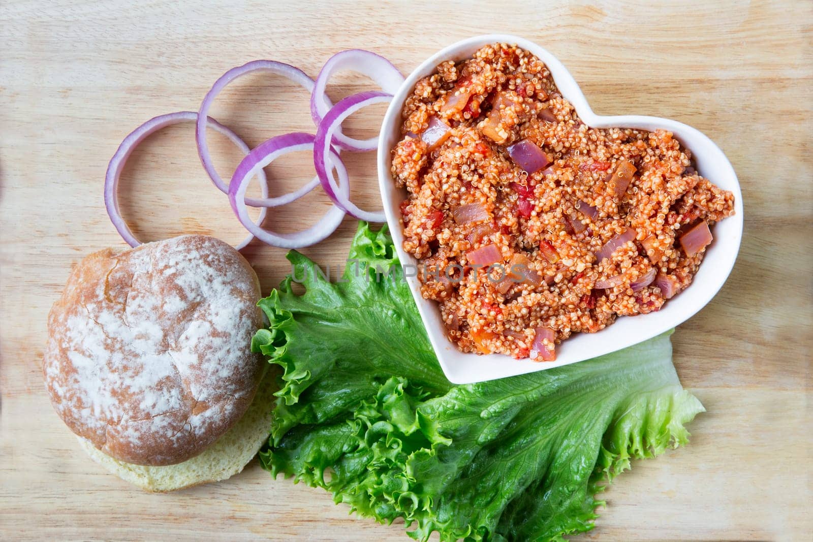 Heart healthy vegan sloppy joe sauce made with quinoa, with a bun, lettuce and onion.