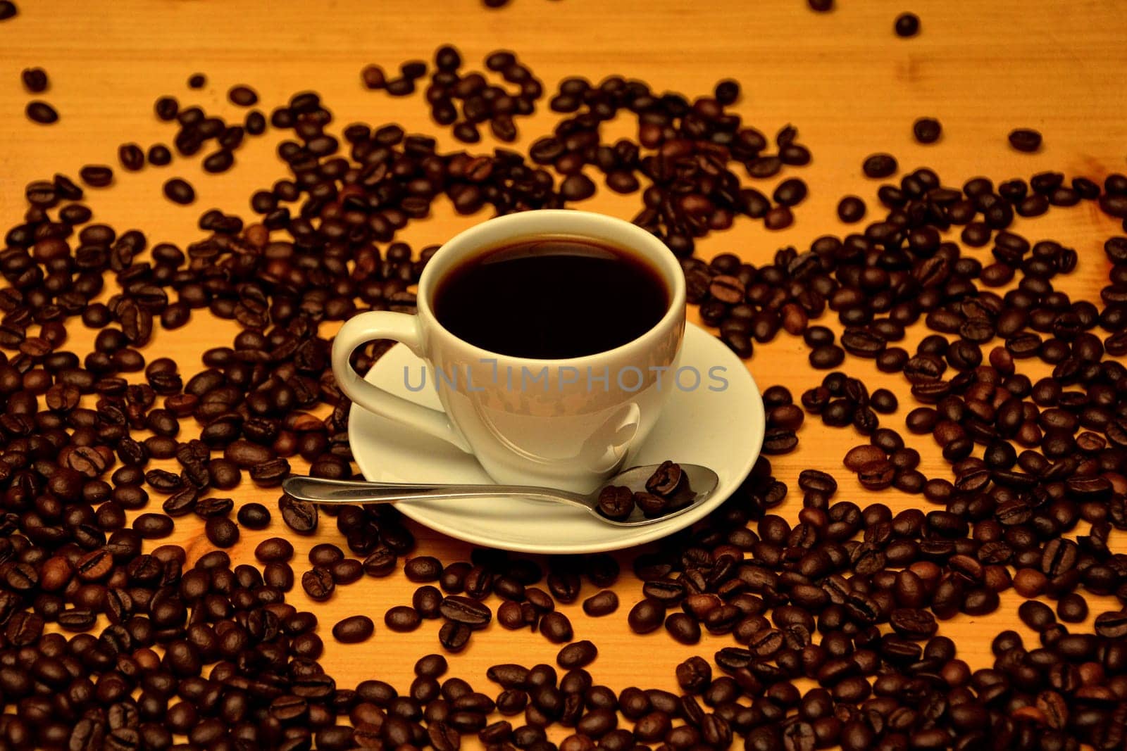 white cup of coffee on wooden table with coffee beans