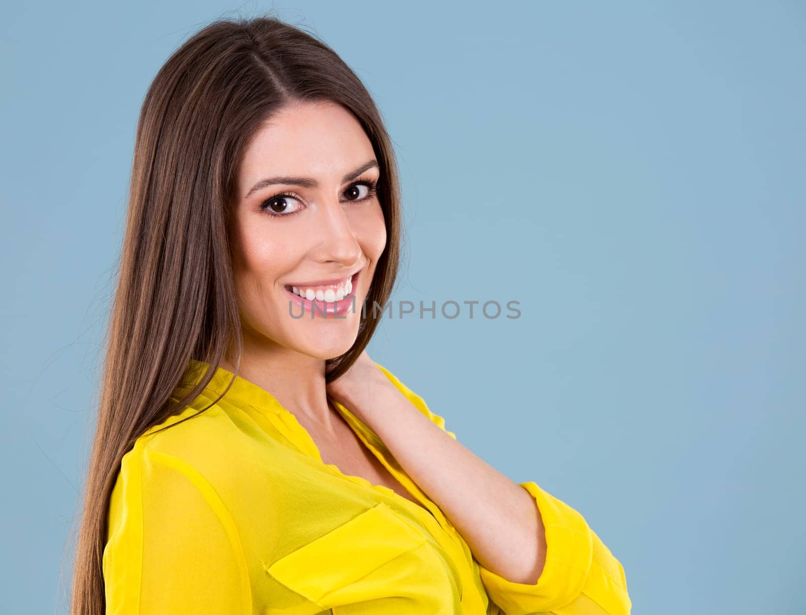 young woman wearing yellow shirt on blue background
