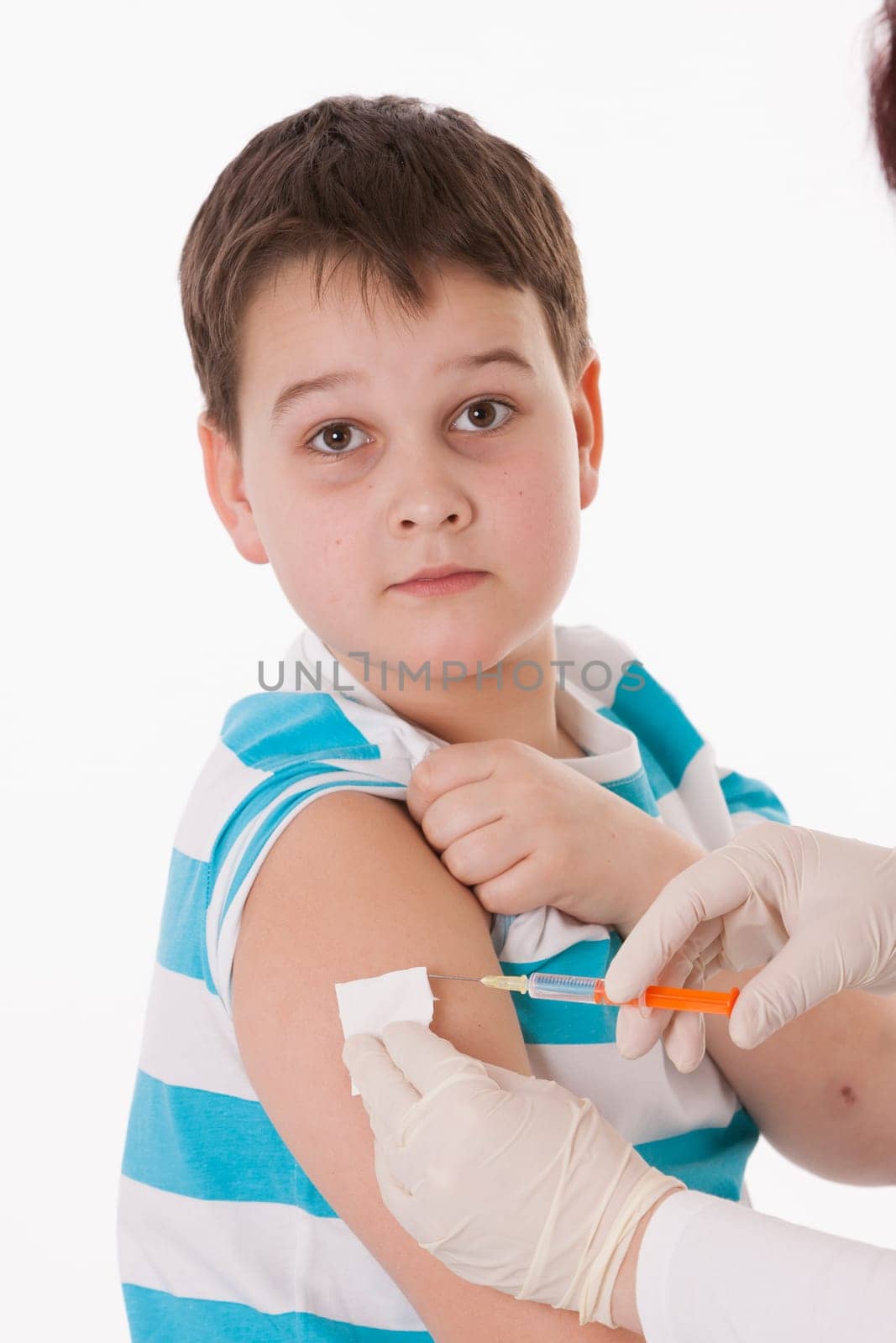 Doctor giving a child injection in arm on isolated image.