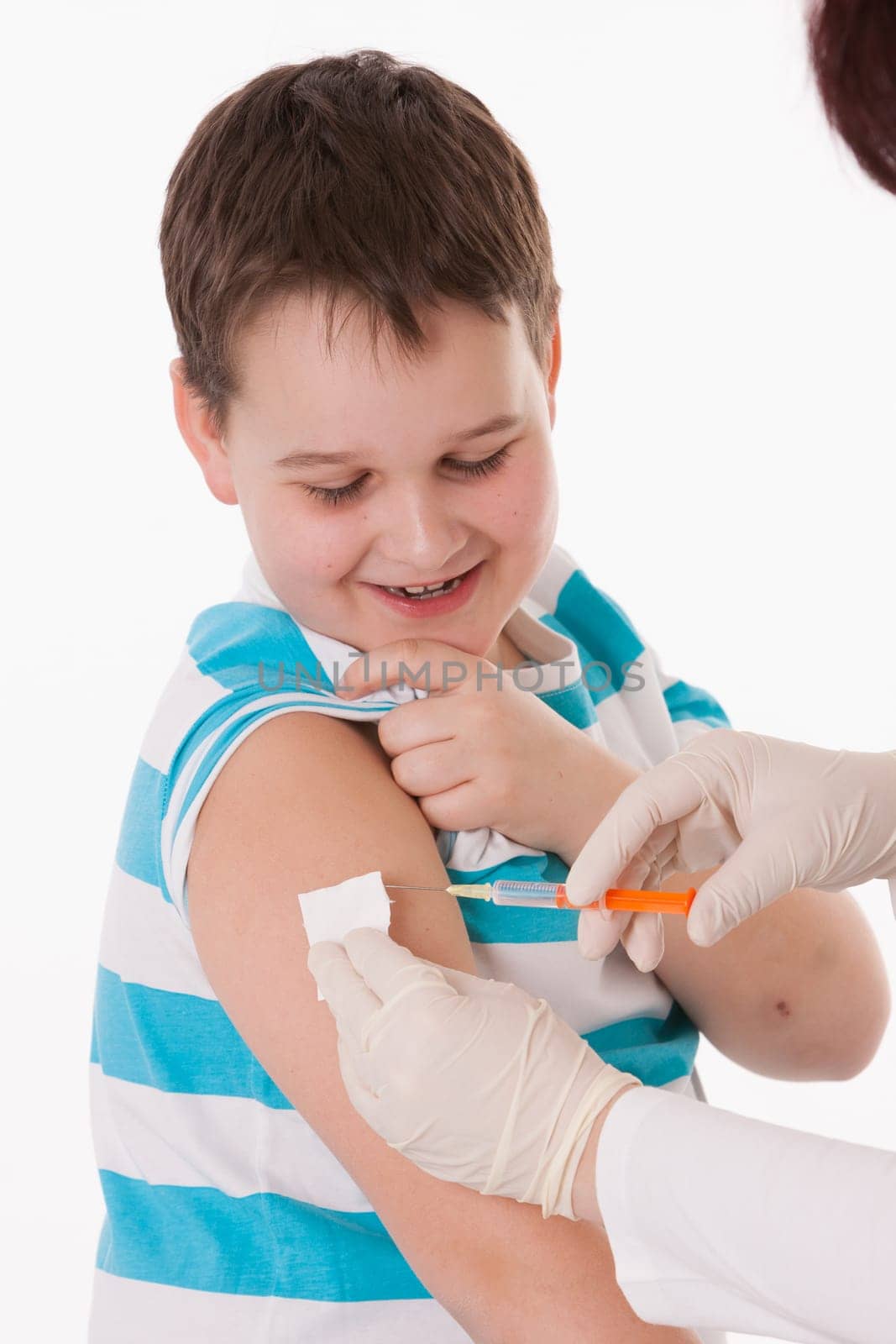 Doctor giving a child injection in arm on isolated image.